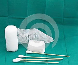 Roll bandage ,sterile gauze and cotton wool on green back ground