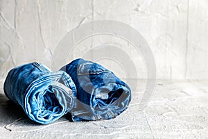 Roll blue denim jeans on gray background