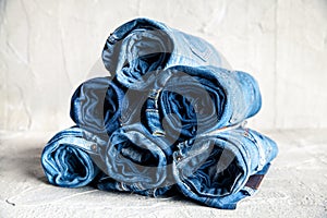 Roll blue denim jeans on gray background