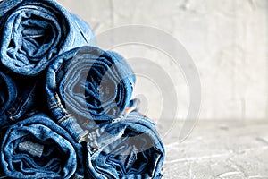 Roll blue denim jeans on gray background