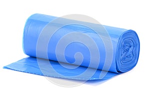 A roll of blue plastic trash bags, lightly rolled out on a horizontal surface
