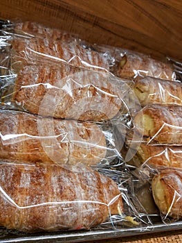 Roll bread filled with milk cream with a sprinkling of powdered sugar on top that has been packed