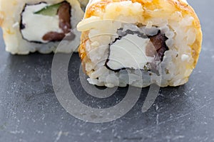 Roll closeup on black background. Traditional Japanese rice food with different additives.