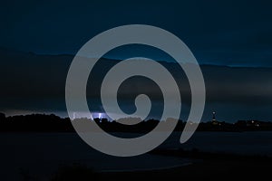 Roll cloud and lightning strikes near a river