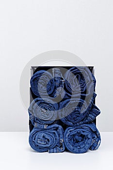 Roll denim jeans arranged in the box.