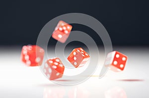 Roll the dice. Risk, luck, gambling, betting or addiction concept. Throwing five red casino and poker dice on table.