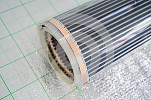 A roll of film underfloor heating lies on the insulation