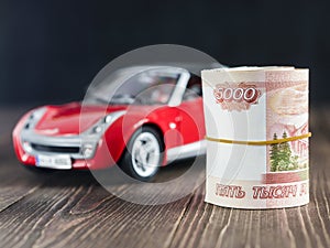 Roll of five thousandth rubles notes on backdrop of toycar photo