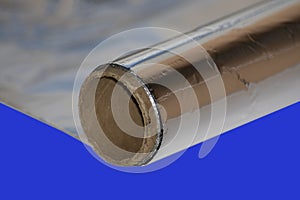 Roll of food foil on blue background.