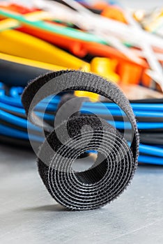 Roll of hook and loop velcro tape used to organize cable in electrical installations