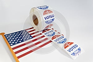 Roll of I Voted Today stickers and american flag on white background. US presidential election concept