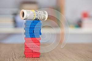 A roll of Japanese Yen banknotes on tall building blocks