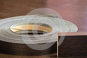 Roll melamine edge for finishing of furniture and laminated chipboard sheets wenge color close-up