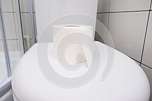 A roll of oilet paper on a toilet cover, concept for constipation and bowel movement