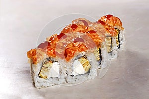 Roll with omelette, a cap of salmon and spicy kimchi sauce isolated