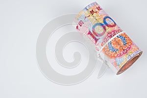 Roll of one hundred chinese yuan banknotes with white robe isolated on white background.