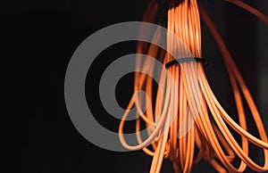 Roll of orange fiber optic cable on a black background