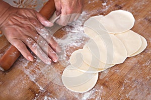 Roll out dumpling wrappers on board