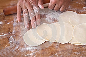 Roll out dumpling wrappers on board