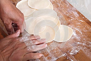 Roll out dumpling wrappers on board