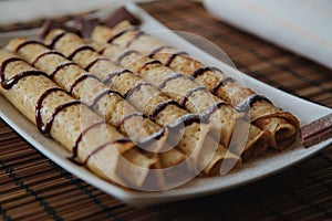 Roll pancake with chocolate on the plate