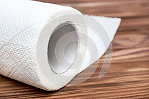 Roll of paper towel on the wooden table. Close up