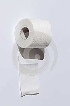 Roll of a perforated toilet paper isolated on a white background close-up. hard shadows from the sun at noon