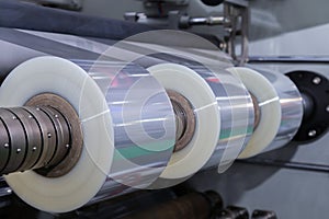 Roll of plastic packaging film on the automatic packing machine in food product factory. industrial and technology concept