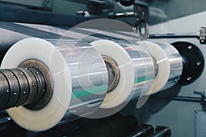 Roll of plastic packaging film on the automatic packing machine in food product factory. industrial and technology concept.