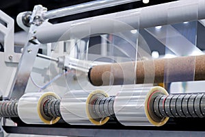 roll of plastic packaging film on the automatic packing machine in food product factory. industrial and technology concept