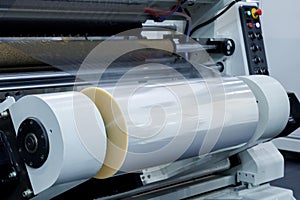 roll of plastic packaging film on the automatic packing machine in food product factory. industrial and technology concept