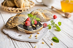 Roll with poppy seed spread, raspberry and pine seeds