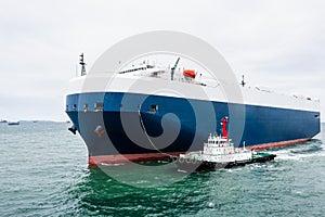 Roll-on Roll-of ship loading new cars line up . Automotive container carriers floating in sea, business services import export