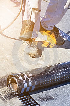 Roll roofing Installation with propane blowtorch during construction works