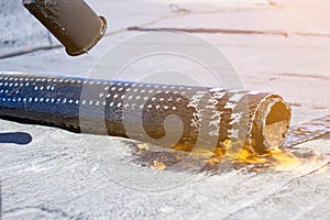 Roll roofing Installation with propane blowtorch during construction works