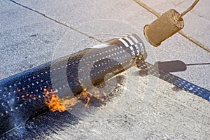Roll roofing Installation with propane blowtorch during construction works