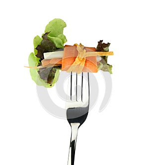 Roll salad on fork isolated on white.