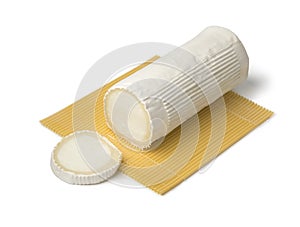 Roll of soft white organic goat cheese and slice