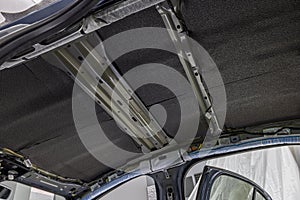 Roll of soundproofing material to car parts. The process of installing the soundproofing of the car. Worker glues soundproofing