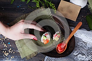 Roll sushi black different tastes, hands, tray, dish crab, carrots, lettuce, tofu, salmon, still life, home, stylish, wooden