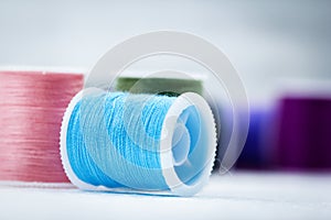 The roll of thread on background,show texture of light blue color thread