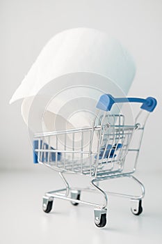 Roll of toilet paper in a decorative shopping trolley. Concept of shortage of goods, panic and paranoia in epidemic of