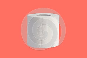 Roll of toilet paper isolated on coral background