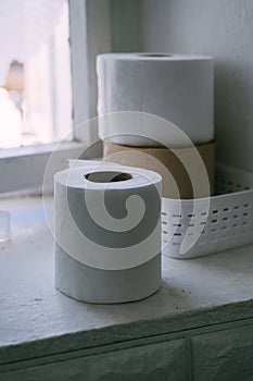 Roll of toilet paper placed on window sill in old rustic bathroom
