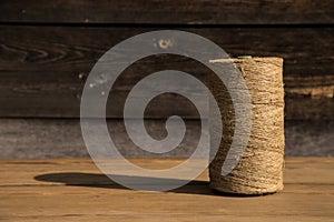 A roll of twine on a wooden background. Selelective focus. Close-up. Free space for text.