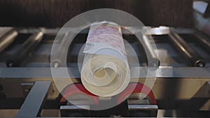 A roll of wallpaper on a conveyor line. Roll of wallpaper. Conveyor line at wallpaper factory