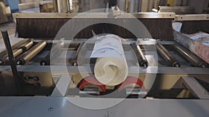 A roll of wallpaper on a conveyor line. Roll of wallpaper. Conveyor line at wallpaper factory