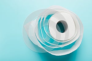 Roll of white toilet paper on a blue background. Top view