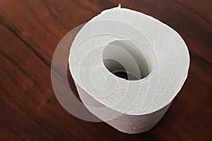 Roll of white toilet paper on a wooden background