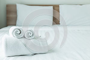 Roll of white towel on the bed table in Luxury modern hotel room